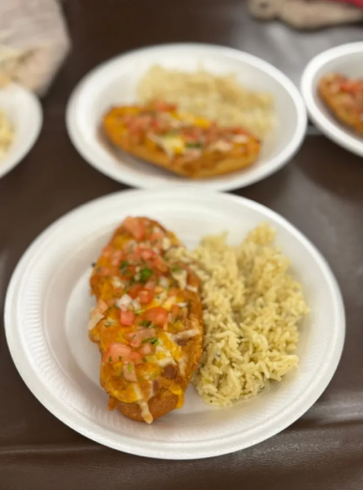 Enchiladas topped with cheese and pico de gallo, served with rice