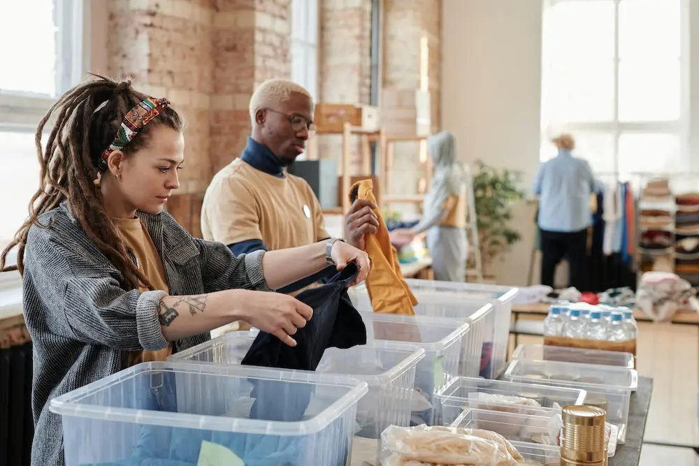 Volunteers sorting and packing clothes into donation bins